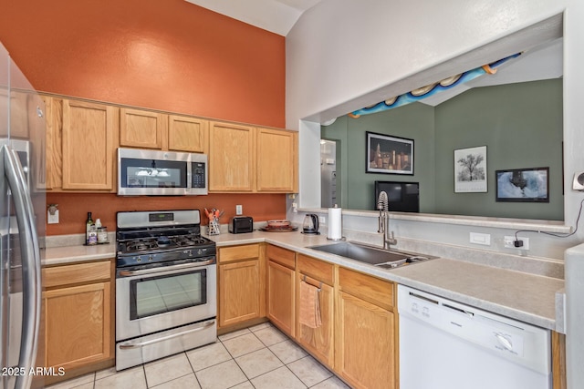 kitchen featuring a sink, light tile patterned floors, stainless steel appliances, light countertops, and lofted ceiling