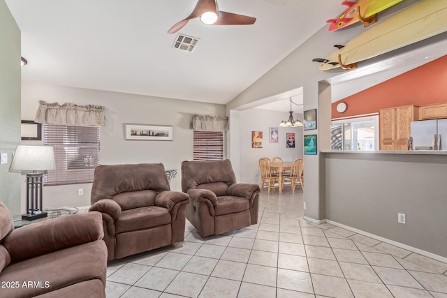 living area featuring light tile patterned flooring, baseboards, visible vents, lofted ceiling, and ceiling fan with notable chandelier