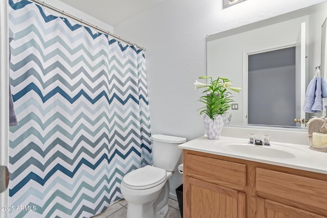bathroom featuring a shower with curtain, toilet, vanity, and tile patterned floors