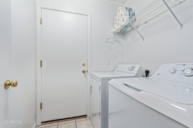 washroom with washing machine and clothes dryer, laundry area, and light tile patterned floors