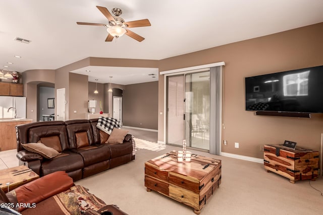 living room with ceiling fan, light colored carpet, and sink