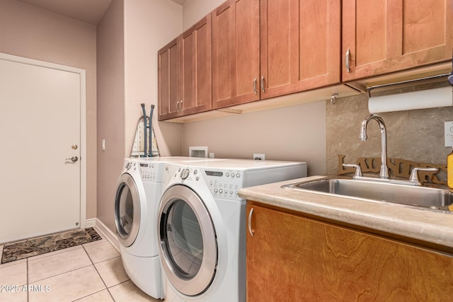 washroom featuring cabinets, sink, washer and dryer, and light tile patterned floors