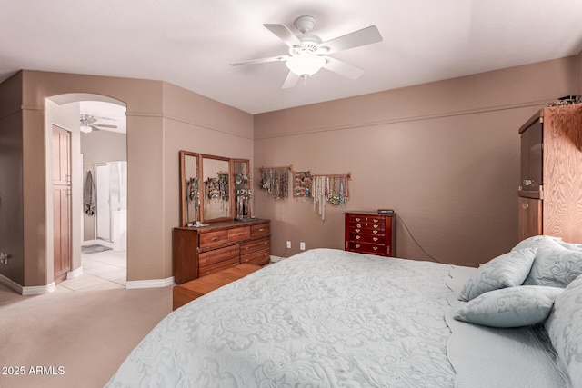 bedroom with connected bathroom, light colored carpet, and ceiling fan