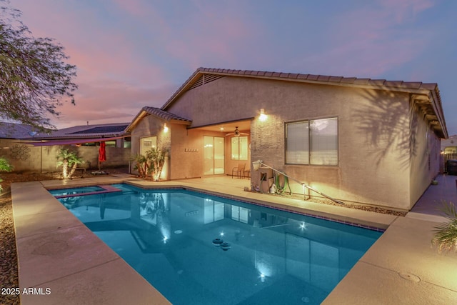 pool at dusk with a patio area