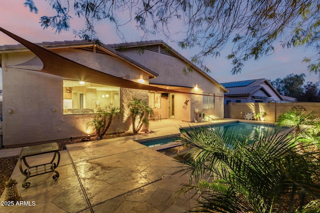 pool at dusk with a patio