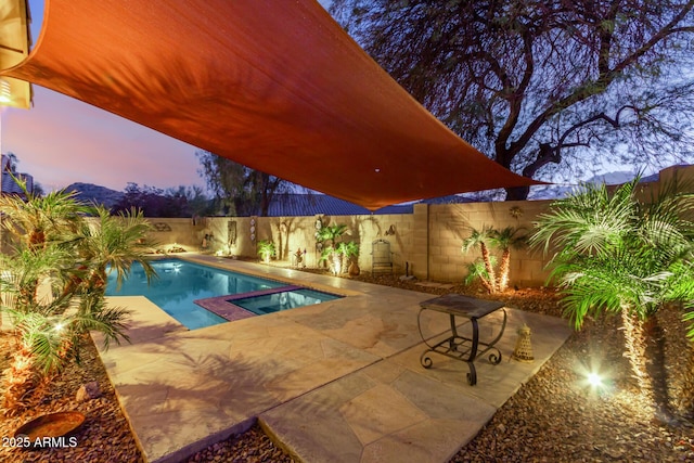 pool at dusk with a patio and a mountain view