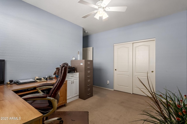 carpeted home office featuring ceiling fan