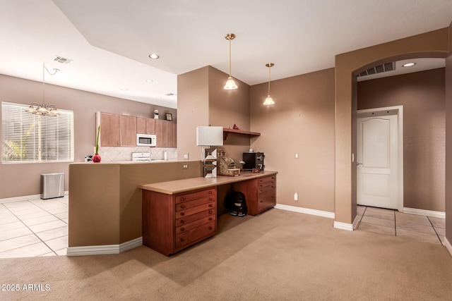 kitchen featuring pendant lighting, range, tasteful backsplash, light carpet, and kitchen peninsula