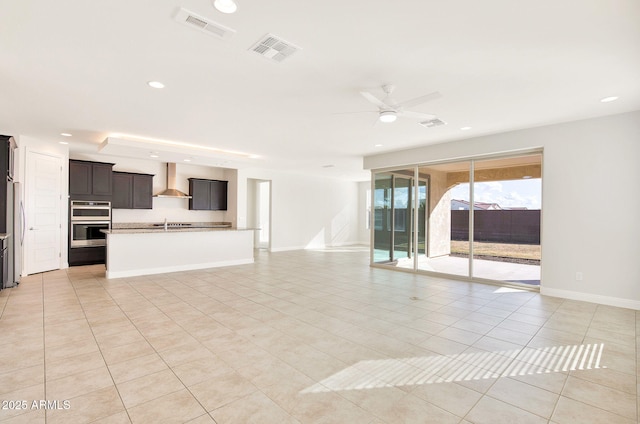 unfurnished living room featuring light tile patterned floors and ceiling fan