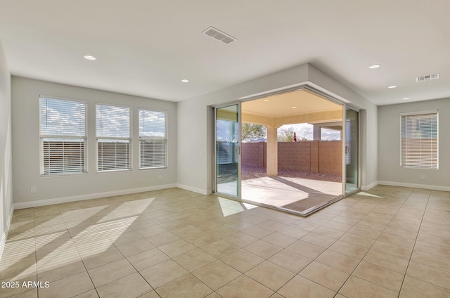 empty room with a wealth of natural light and light tile patterned floors