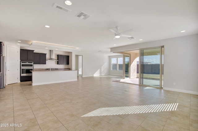 unfurnished living room featuring light tile patterned flooring and ceiling fan