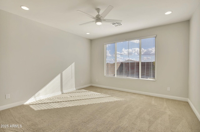 spare room with light colored carpet and ceiling fan