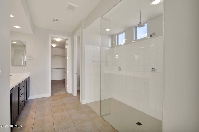 bathroom with vanity, tile patterned flooring, and a tile shower