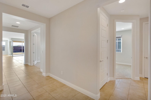 hall with light tile patterned floors