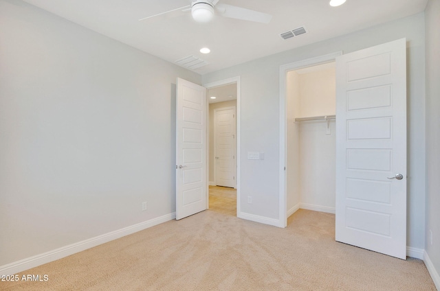 unfurnished bedroom with ceiling fan, light colored carpet, and a closet