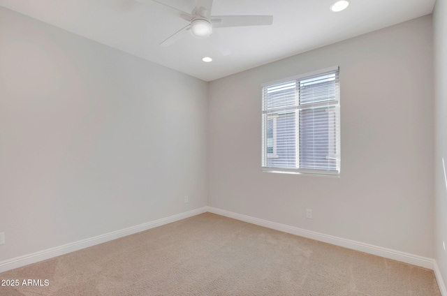 carpeted spare room featuring ceiling fan