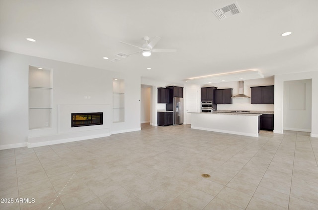 unfurnished living room featuring built in features and ceiling fan