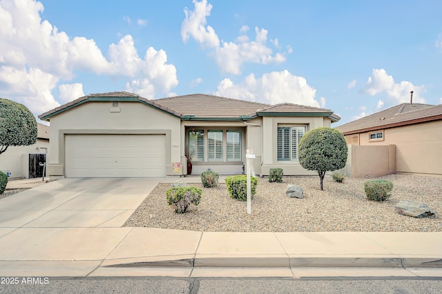 view of front of home featuring a tile roof, stucco siding, fence, a garage, and driveway