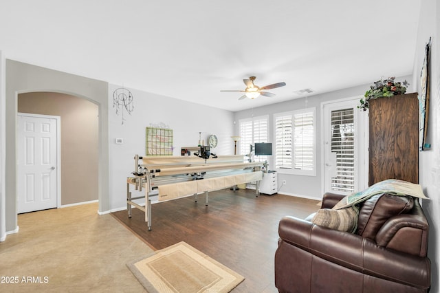 office space featuring arched walkways, visible vents, ceiling fan, and baseboards