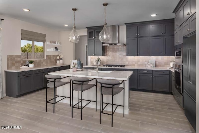 26982 N 168th Ln, Surprise, AZ 85387 - kitchen featuring wall chimney exhaust hood, a sink, a kitchen bar, stainless steel appliances, and light wood-style flooring