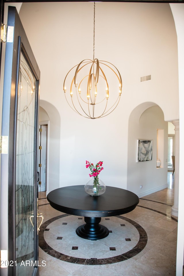 10754 E Laurel Ln, Scottsdale, AZ 85259 - entryway with inlaid floor details, arched walkways, a high ceiling, and a chandelier