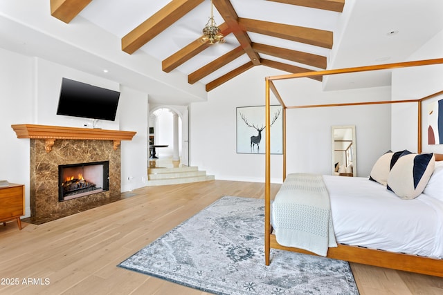10754 E Laurel Ln, Scottsdale, AZ 85259 - bedroom featuring a fireplace, wood finished floors, and arched walkways