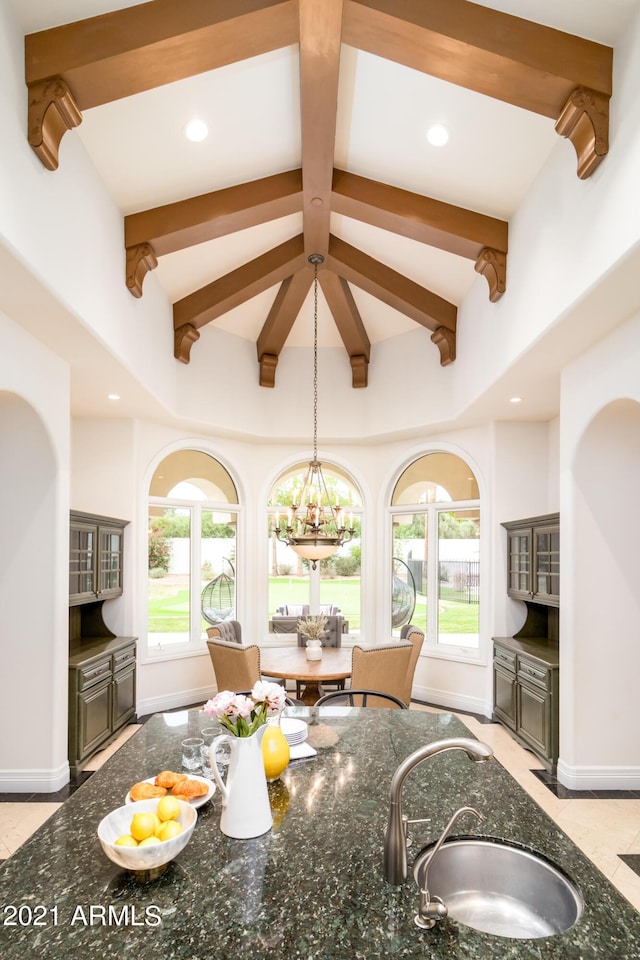 10754 E Laurel Ln, Scottsdale, AZ 85259 - kitchen featuring beam ceiling, dark stone counters, pendant lighting, a chandelier, and a towering ceiling