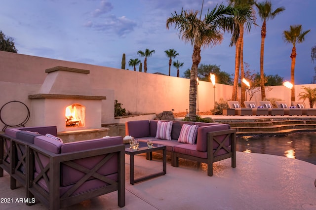 10754 E Laurel Ln, Scottsdale, AZ 85259 - patio terrace at dusk featuring an outdoor living space with a fireplace, a fenced backyard, and a patio area