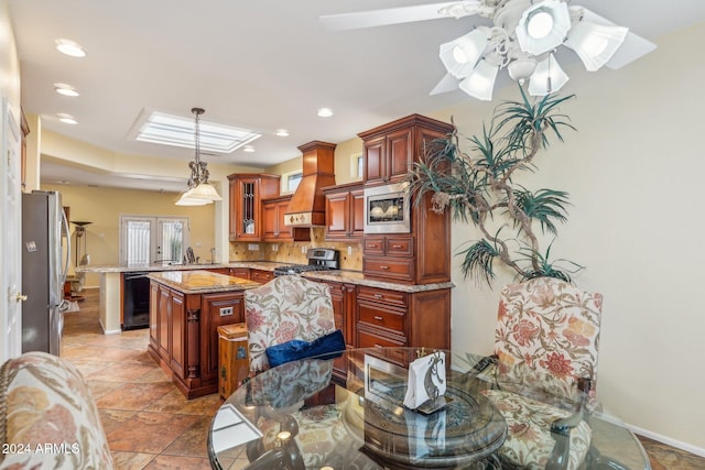 kitchen featuring sink, custom range hood, appliances with stainless steel finishes, a kitchen island, and kitchen peninsula