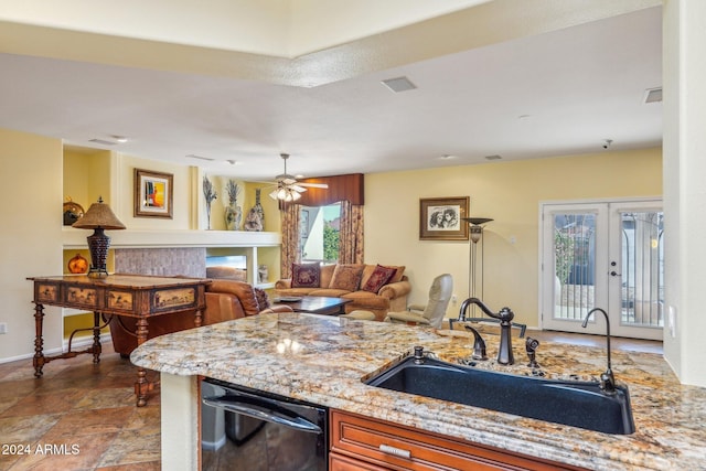 kitchen with dishwasher, french doors, sink, ceiling fan, and light stone counters