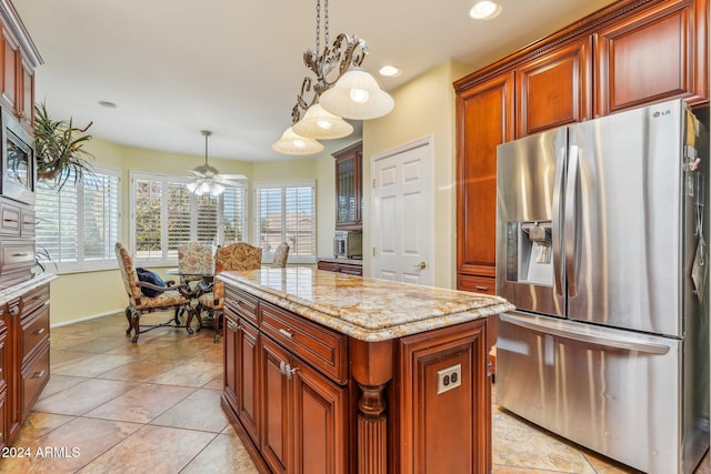 kitchen featuring ceiling fan, a center island, plenty of natural light, decorative light fixtures, and appliances with stainless steel finishes