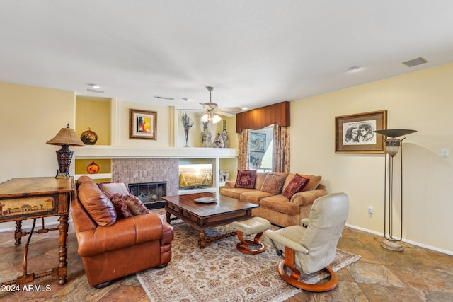 living room with a tile fireplace and ceiling fan