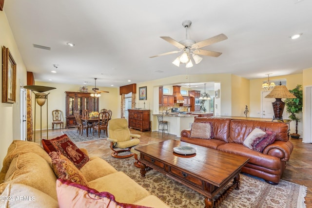 living room featuring ceiling fan with notable chandelier