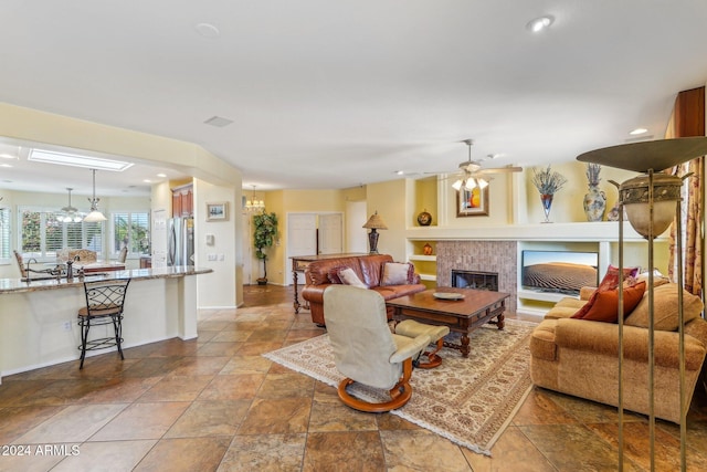 living room featuring built in features, ceiling fan, and a tiled fireplace