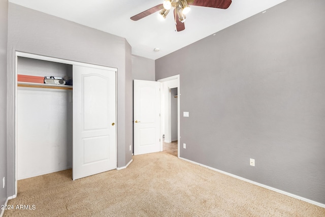 unfurnished bedroom featuring light colored carpet, a closet, and ceiling fan