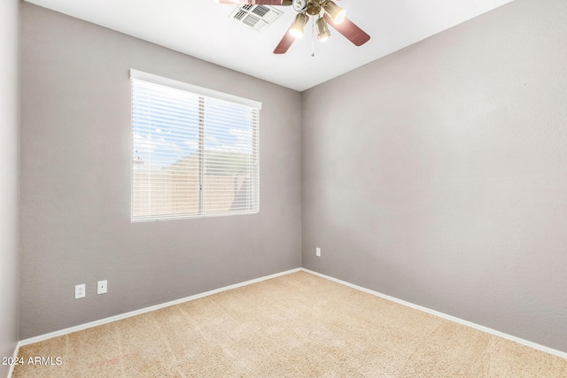 carpeted spare room featuring ceiling fan