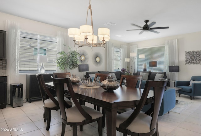 tiled dining area with ceiling fan with notable chandelier