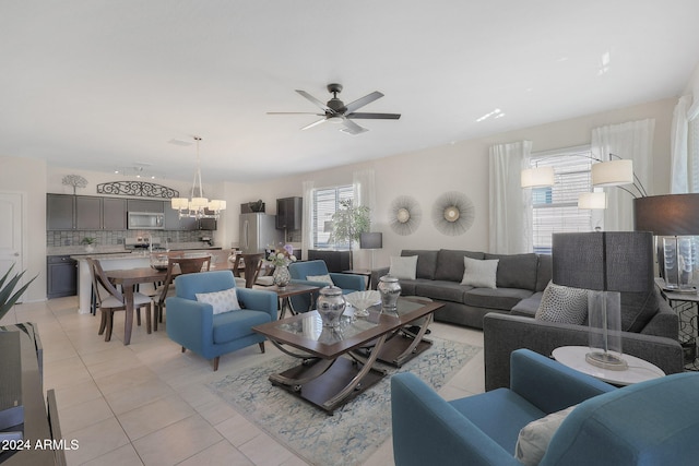 living room featuring ceiling fan with notable chandelier and light tile patterned flooring