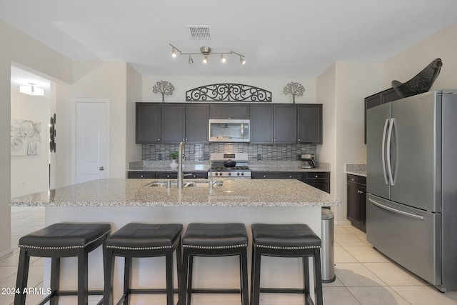 kitchen featuring sink, an island with sink, and appliances with stainless steel finishes