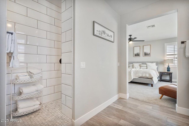 bathroom featuring visible vents, baseboards, connected bathroom, wood finished floors, and a ceiling fan