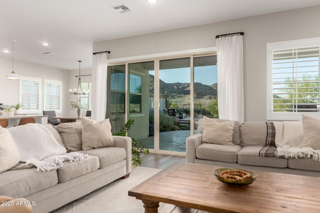 21186 W Hillcrest Blvd, Buckeye, AZ 85396 - living area featuring recessed lighting, a chandelier, healthy amount of natural light, wood finished floors, and a mountain view