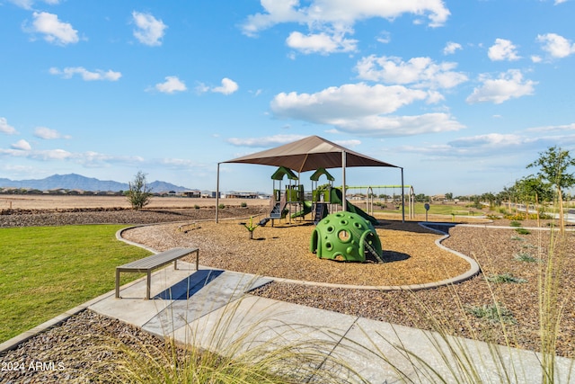 view of jungle gym with a lawn and a mountain view