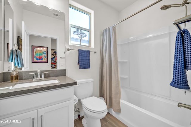 full bathroom with hardwood / wood-style floors, vanity, toilet, and shower / tub combo with curtain