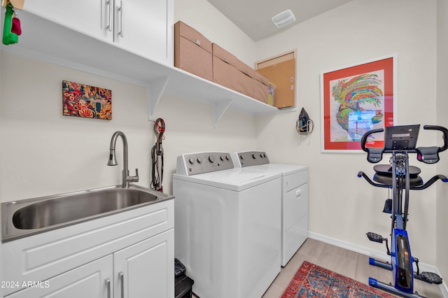 washroom featuring cabinets, washer and clothes dryer, and sink