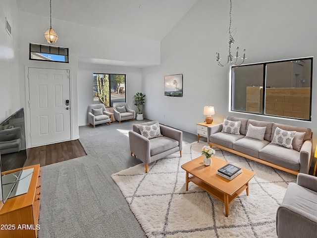 living room with carpet, a notable chandelier, and high vaulted ceiling