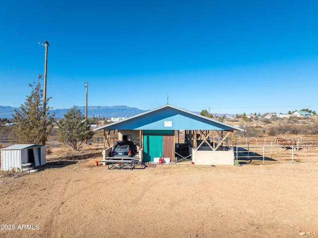 view of pole building featuring a mountain view, a carport, and fence