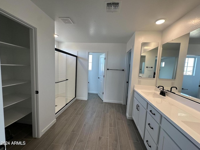 bathroom with vanity, wood-type flooring, and walk in shower