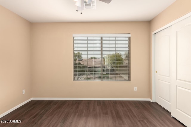 unfurnished bedroom featuring ceiling fan, dark hardwood / wood-style flooring, and a closet