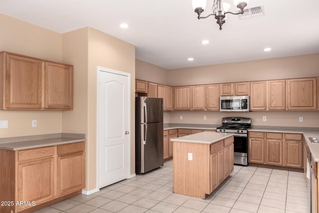 kitchen featuring an inviting chandelier, appliances with stainless steel finishes, light brown cabinetry, and a kitchen island