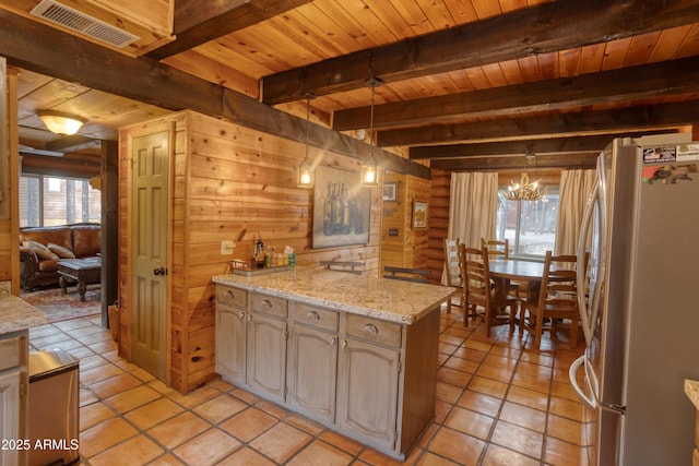 kitchen featuring stainless steel refrigerator, beamed ceiling, a notable chandelier, decorative light fixtures, and wood ceiling